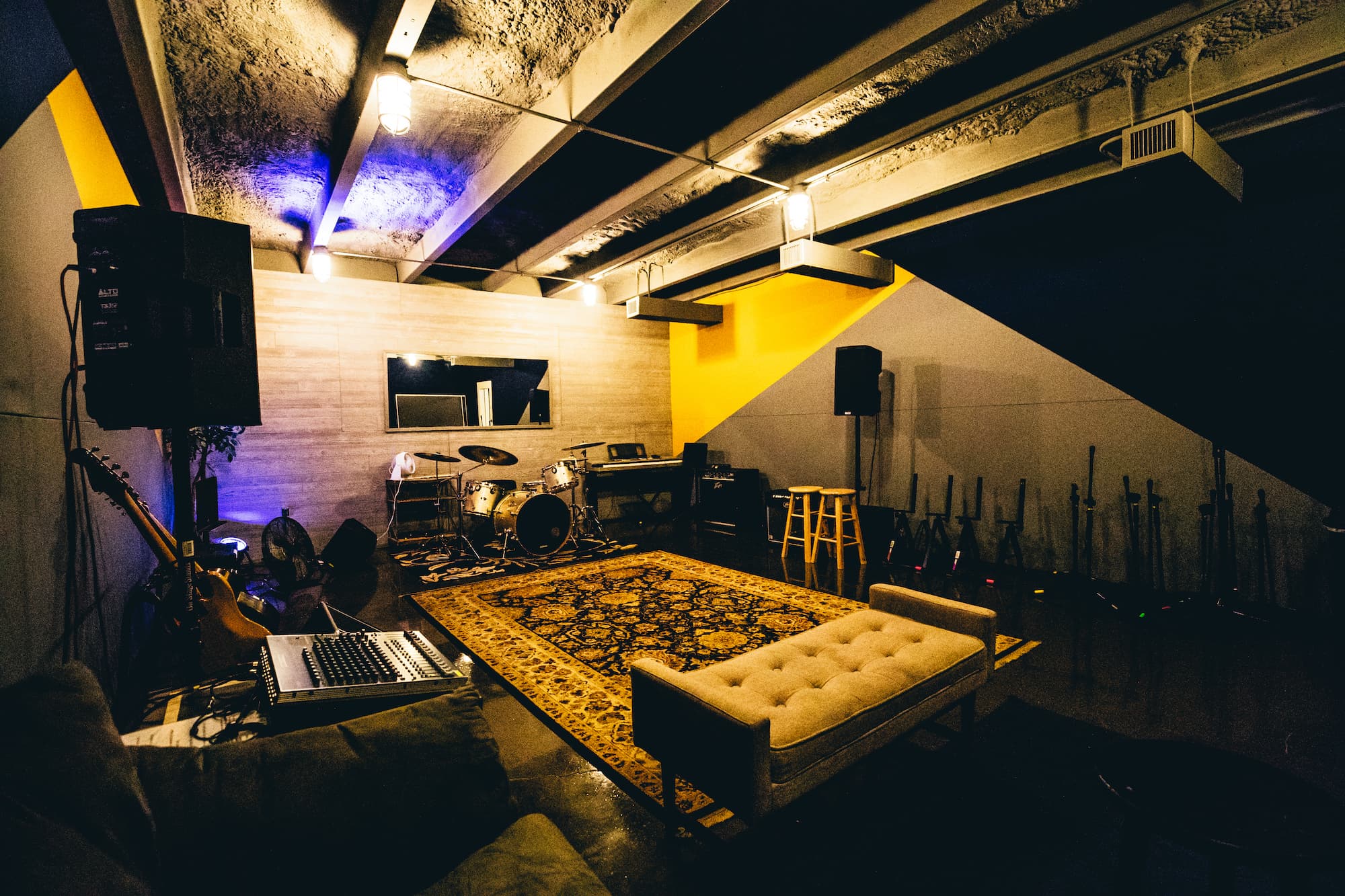 Studio B live room with drums, mixing board, and lounge seating